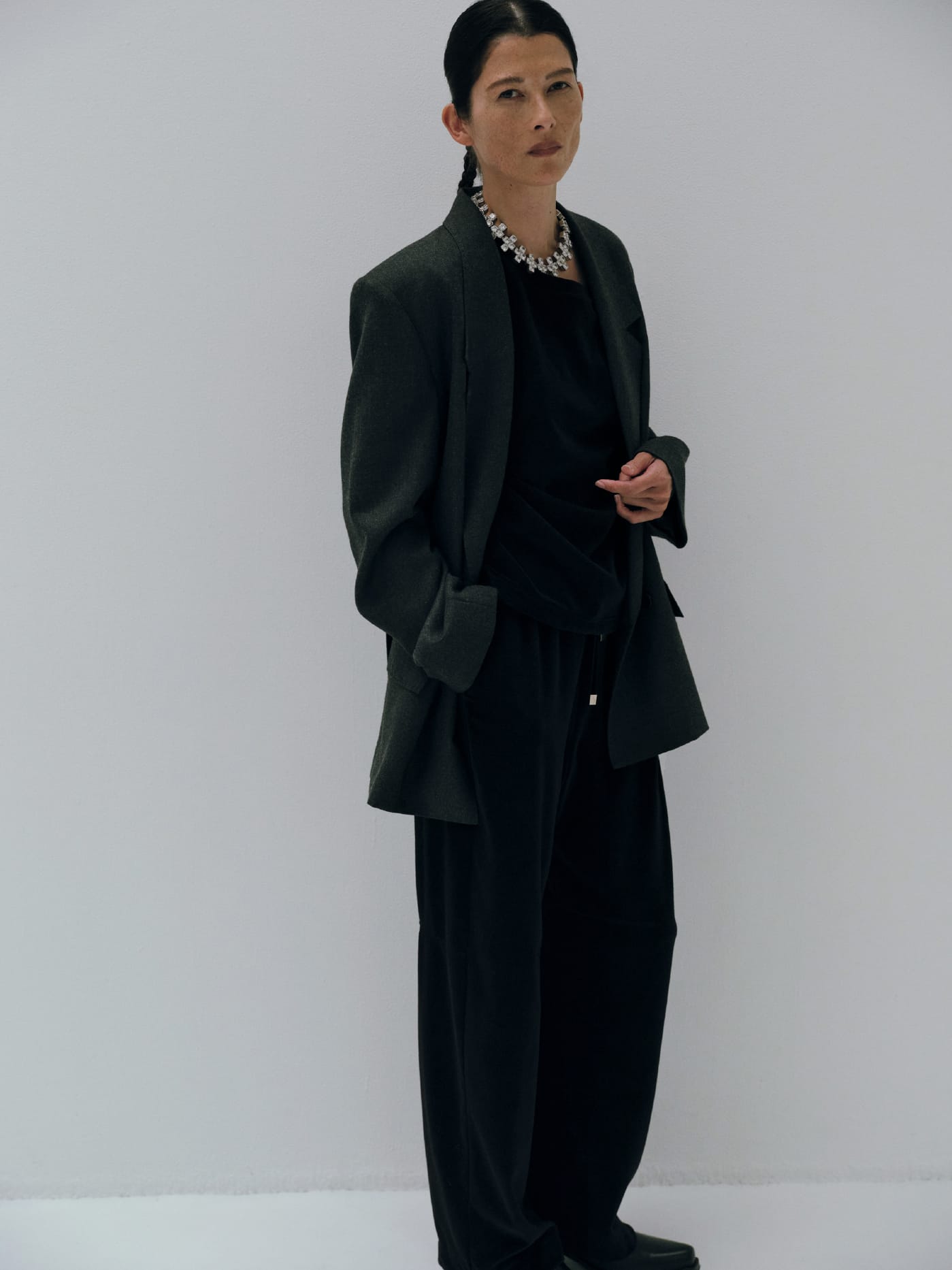 Double-breasted suit jacket & Velour asymmetric top & Velvet cocoon pantsを着た女性