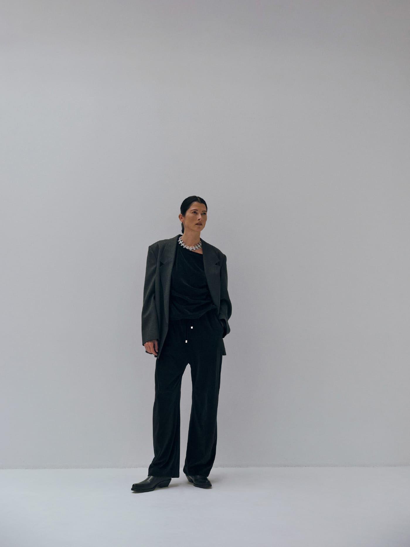Double-breasted suit jacket & Velour asymmetric top & Velvet cocoon pantsを着た女性