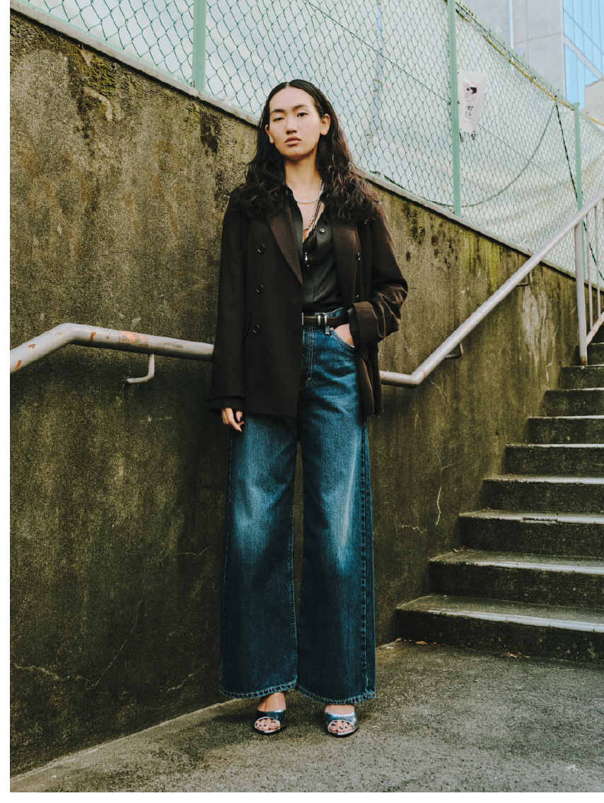 バックスリットスーツジャケット&LEEコラボデニムパンツを着用した女性